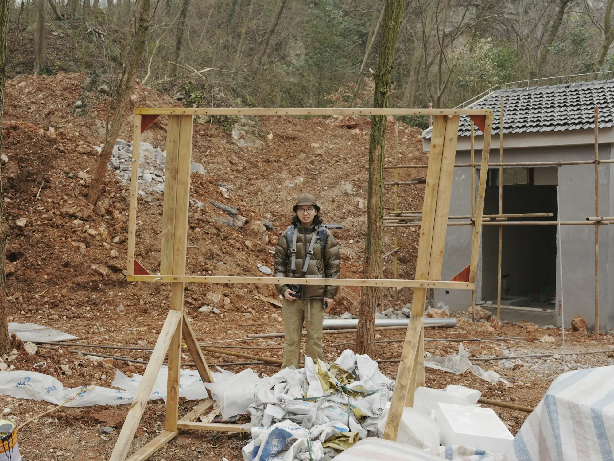 Builder standing behind a timber wall frame on a residential building site