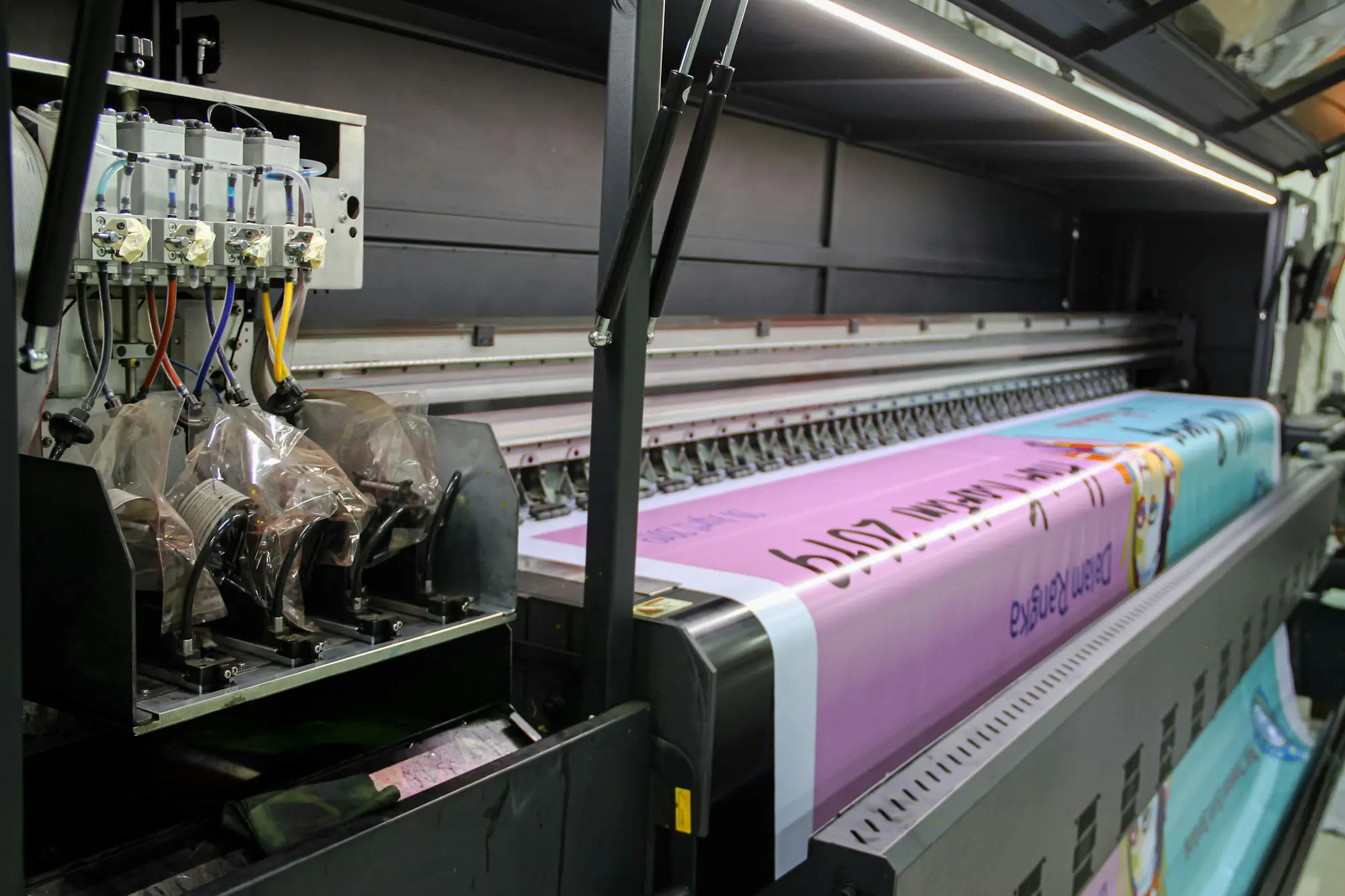 Large-format printer producing a printed banner in a print shop