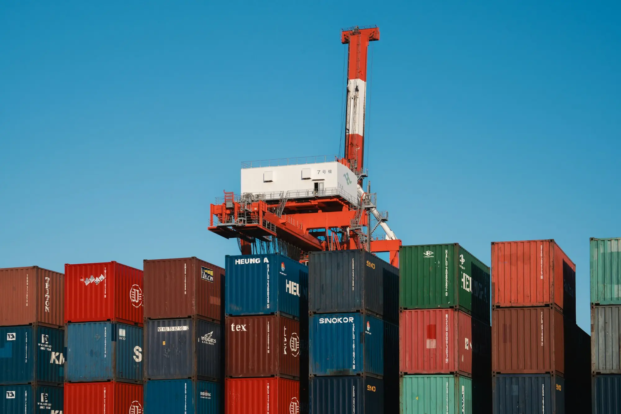 Gantry crane above stacked shipping containers at a port terminal